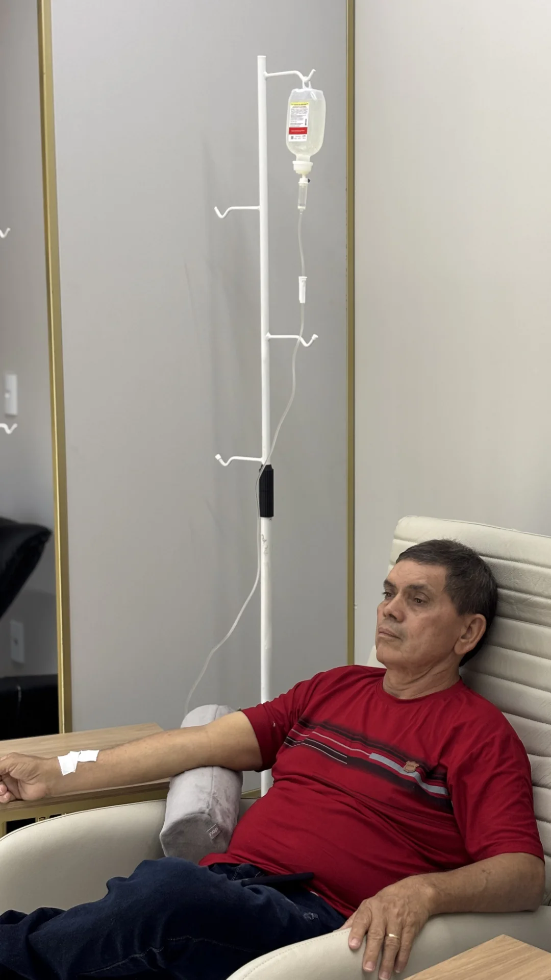 Paciente em poltrona recebendo terapia endovenosa na clínica